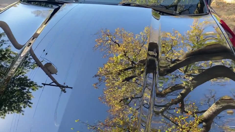Reflections on a dark vehicle’s paintwork